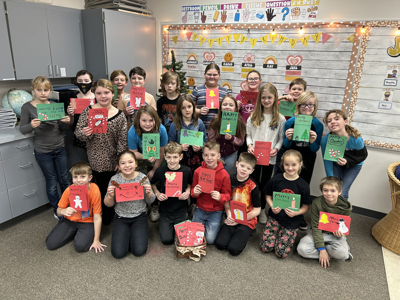 4th grade students holding Christmas cards