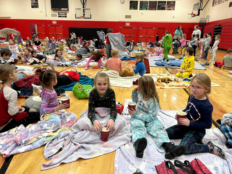 elementary students with blankets watching a movie