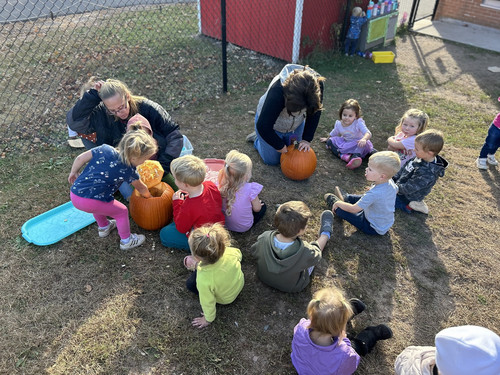 children helping carve a pumpkin